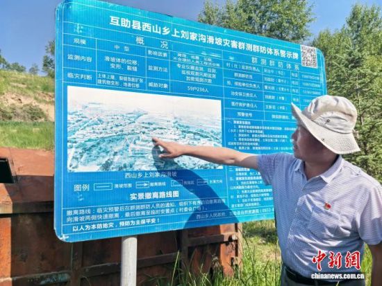 资料图为海东市互助县西山乡工作人员介绍滑坡灾害防治情况。李隽 摄 资料图为海东市互助县西山乡工作人员介绍滑坡灾害防治情况。李隽 摄