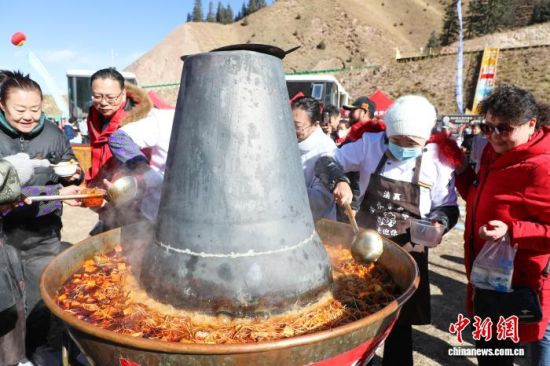 图为民众品尝巨型祁连暖火锅。马铭言 摄 图为民众品尝巨型祁连暖火锅。马铭言 摄