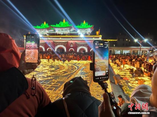 12月14日,塔尔寺燃灯日现场,参与者用手机进行直播。中新社记者 陈宗淇 摄 12月14日,塔尔寺燃灯日现场,参与者用手机进行直播。中新社记者 陈宗淇 摄