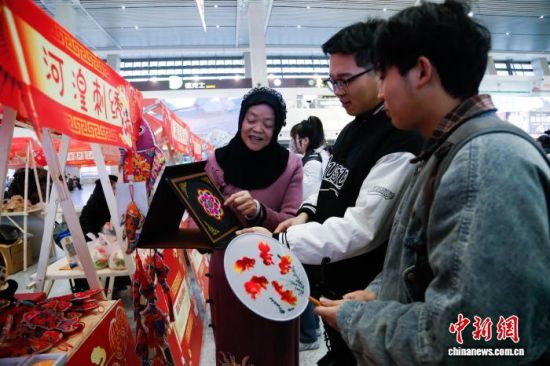 资料图为西宁火车站,旅客在特色集市上了解“青绣”。马铭言 摄 资料图为西宁火车站,旅客在特色集市上了解“青绣”。马铭言 摄