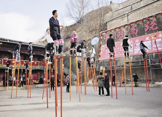 年轻人踩着高跷,和着鼓点练习。李庆玲 摄 年轻人踩着高跷,和着鼓点练习。李庆玲 摄