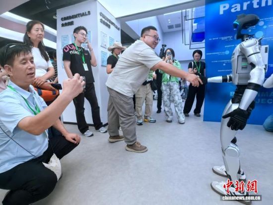 图为网络名人代表在园区内与机器人互动。李隽 摄 图为网络名人代表在园区内与机器人互动。李隽 摄