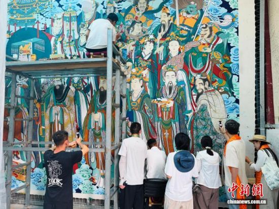 图为网络名人们对画师进行拍摄。孙睿 摄 图为网络名人们对画师进行拍摄。孙睿 摄