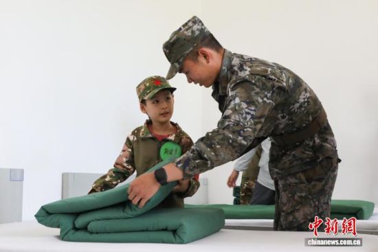 图为“萌娃”学习叠“豆腐块”被子。 马铭言摄 图为“萌娃”学习叠“豆腐块”被子。 马铭言摄
