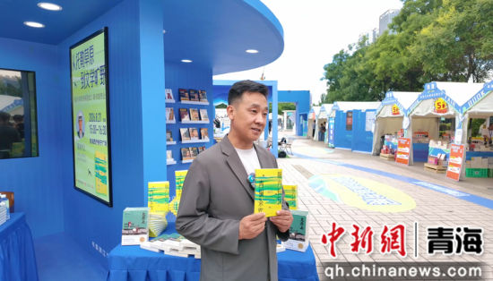 图为青海本土作家索南才让在西部书展签售现场,向读者展示新作。青海出版传媒集团 供图 图为青海本土作家索南才让在西部书展签售现场,向读者展示新作。青海出版传媒集团 供图