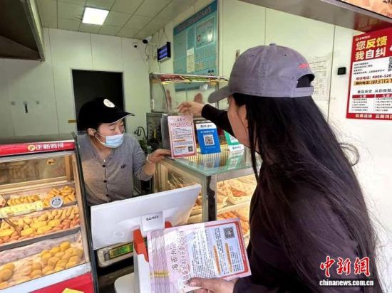资料图为青海省海西州商务部门工作人员向商家宣传有奖发票政策。青海省商务厅供图 资料图为青海省海西州商务部门工作人员向商家宣传有奖发票政策。青海省商务厅供图