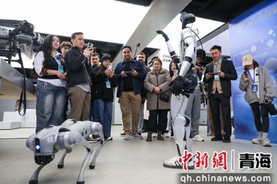 图为中亚青年近距离接触机器人。马铭言 摄 图为中亚青年近距离接触机器人。马铭言 摄