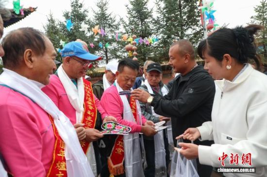 9月28日,赴青海省西宁市湟中区李家山镇吉家村祭祖的台胞收到村民亲手缝制的鞋垫。马铭言 摄 9月28日,赴青海省西宁市湟中区李家山镇吉家村祭祖的台胞收到村民亲手缝制的鞋垫。马铭言 摄