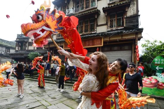 图为海外游客在重庆体验舞龙。中新网记者 何蓬磊 摄 图为海外游客在重庆体验舞龙。中新网记者 何蓬磊 摄